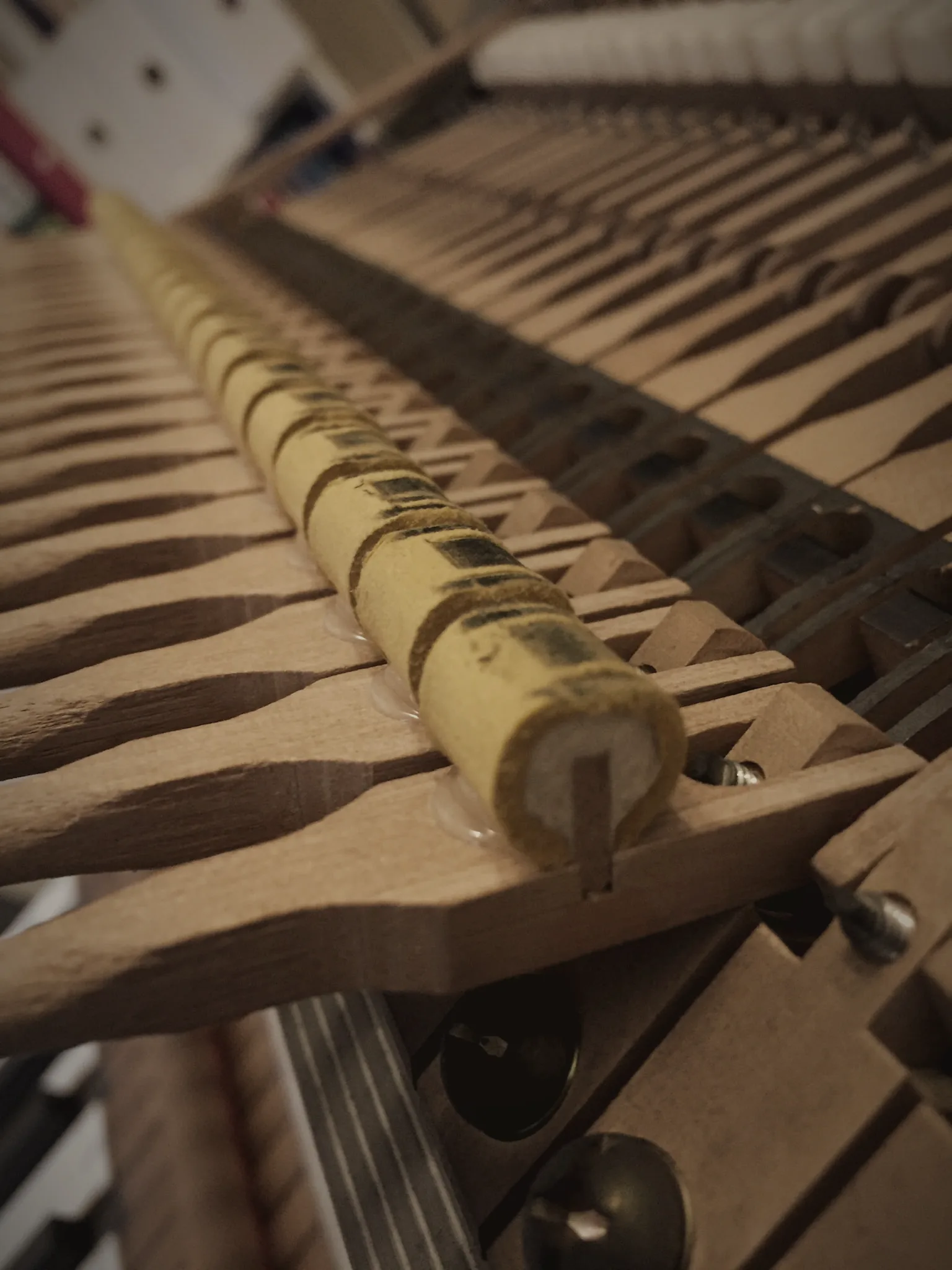 Rows of hammer shanks and knuckles inside a grand piano action