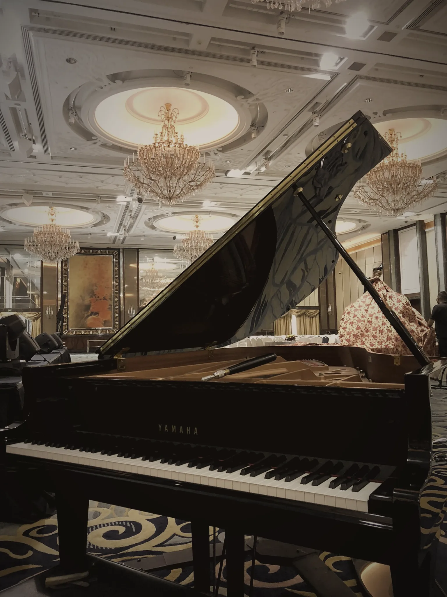 Yamaha grand piano with its lid raised in a hotel ballroom